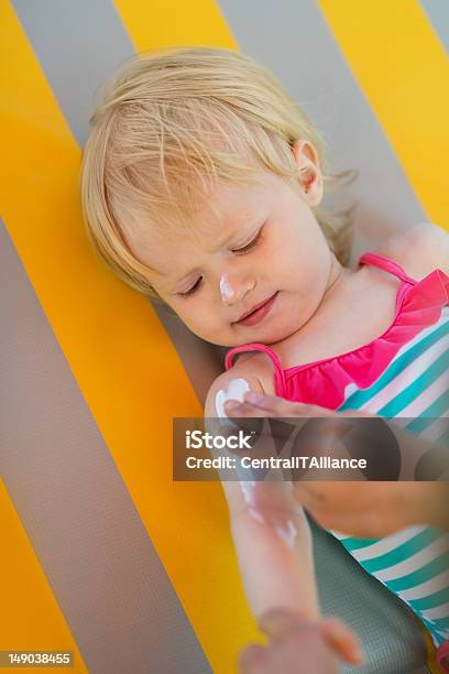 Baby Waiting While Mother Applying Sun Block Creme On Arm Stock Photo - Download Image Now