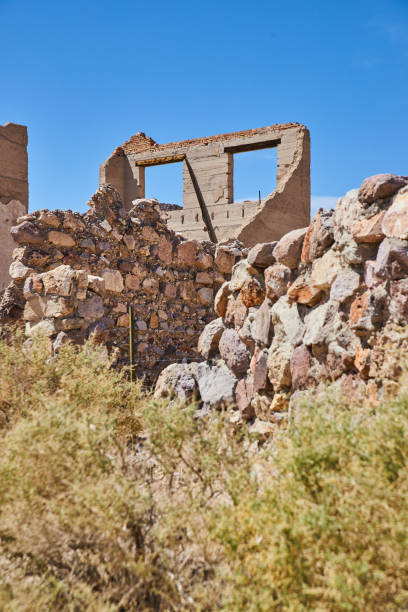 istock Ghost town abandoned building with stone walls and shrubs 1490385229
