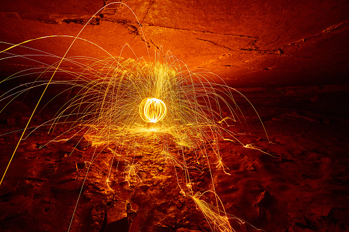 Image of Globe of orange and yellow sparks inside a cave giving an ominous red glow