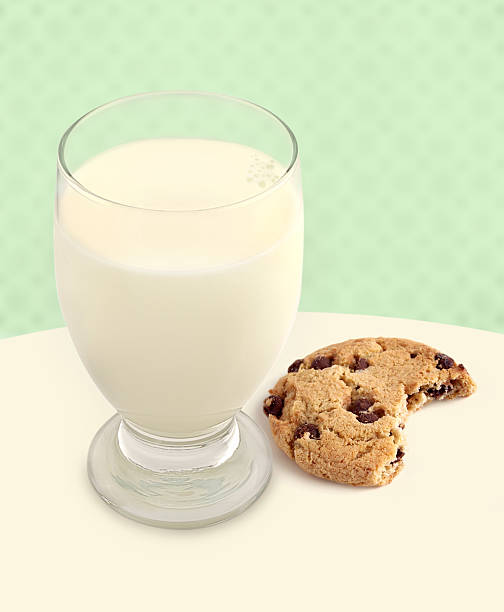 Milk and Cookie with Bite Taken on Green background