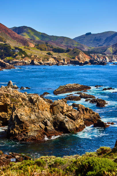 istock Iconic Highway One bridge in distance with waves and rocky cliffs 1490389924