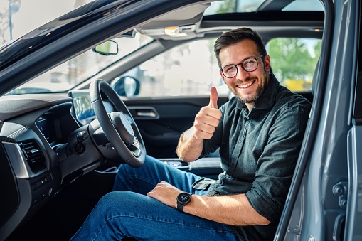 Portrait of a happy customer buying a new car