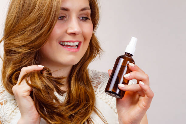 istock Woman applying hair cosmetic 1490394892