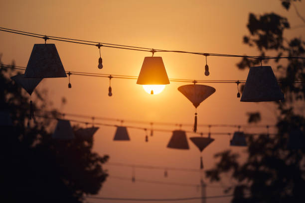 Traditional lanterns hanging above the street in Hoi An in Vietnam. The sun looking like bulb in lamp.