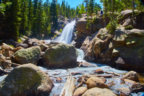istock Large waterfall into boulders surrounded by pine trees 1490395369