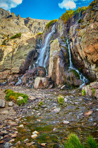 istock Large waterfall into stream up in mountains with mossy rocks 1490395385