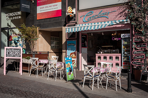 Sliema, Malta - April 19, 2023: Front of Carolinas Petit Cafe' & Tearoom. Pink vintage tables and chairs outdoor in the street.