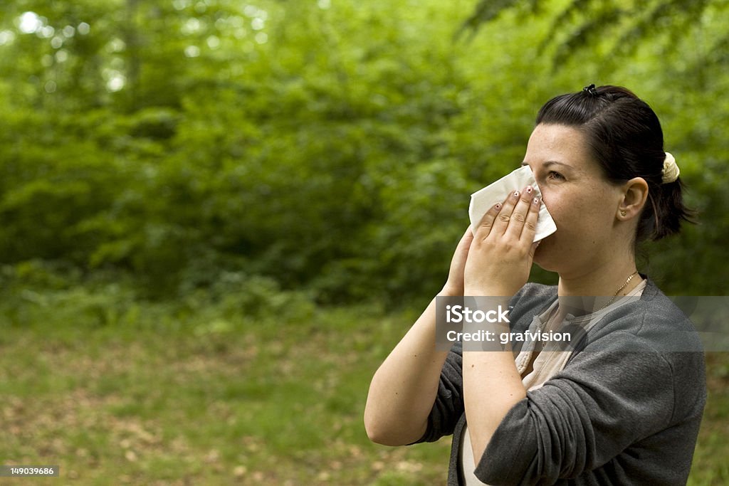 allergy brunette woman having a pollen allergy in the forest Adult Stock Photo
