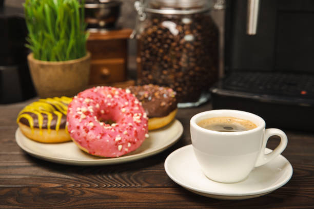 istock Fragrant delicious espresso coffee with pink strawberry donut, coffee machine on brown texture table. Good morning concept. Morning coffee. Sweet table. Colorful berry buns.Top view. 1490399537