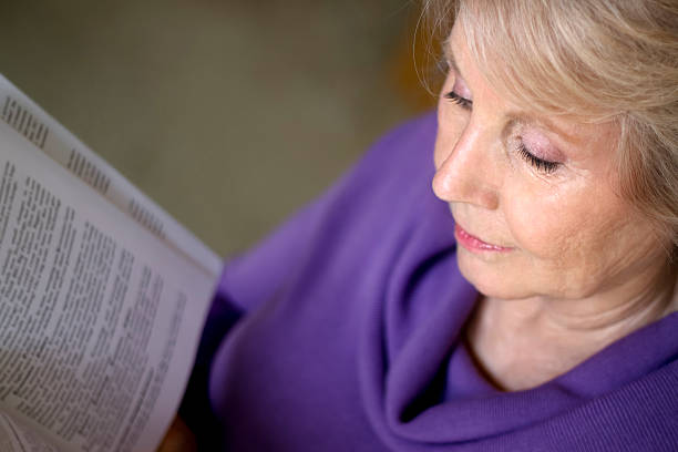 Mature older woman reading a book stock photo