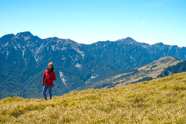 Hikers stand on top of a mountain looking at view.