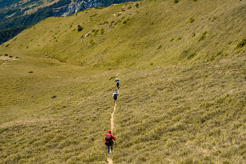 Hikers walking alone on top of a mountain.