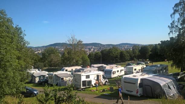 parken von wohnmobilen in einem sommercamp vor dem hintergrund grüner bäume und blauem himmel - camping mobile home vacations tent stock-fotos und bilder