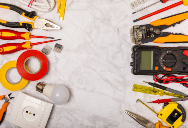 istock Electrician equipment on white background with copy space.Top view.Electrician tool set.Multimeter, tester,screwdrivers,wire pliers,duct tape, lamps, tape measure and wires.Flet lay. 1490403276