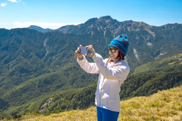Mountain hiker taking photos on the mountain top.