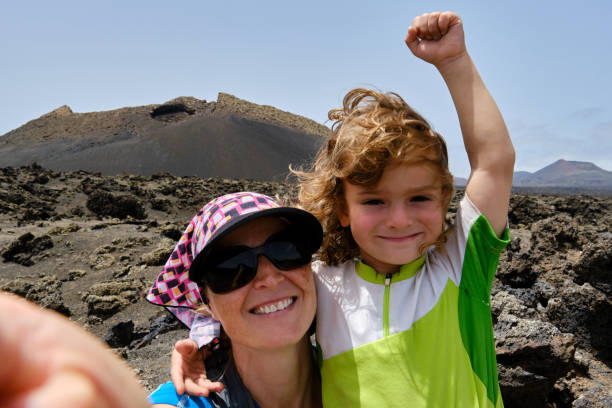 Mother and son taking a selfie while hiking between volcanoes. Lanzarote. stock photo