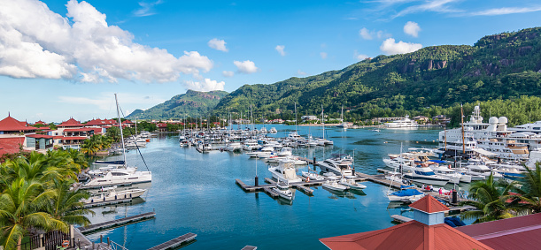 Beautiful panoramic landscape with luxury yachts and boats in the harbor of Mahe Island, Seychelles.