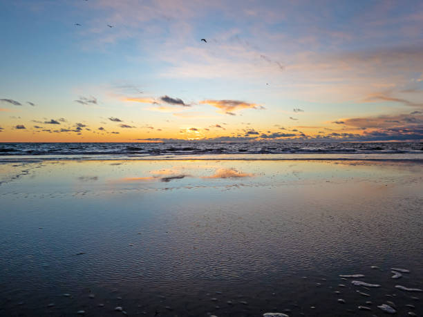 istock Sunset over the sea with reflections in the rising surf 1490409240