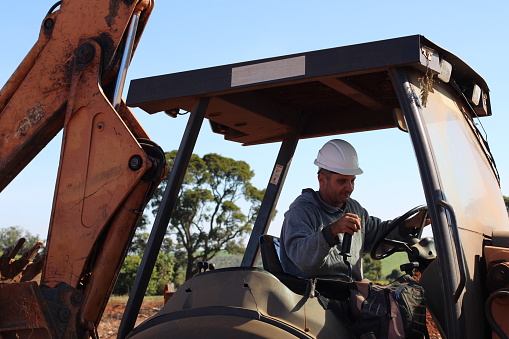 Man Using Backhoe Man Operating A Backhoe Machine Stock Photo - Download Image Now ...