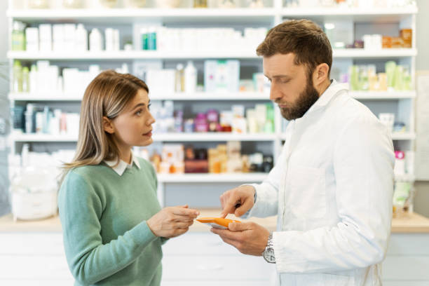 istock Male pharmacist working in drugstore talking with customer 1490413467