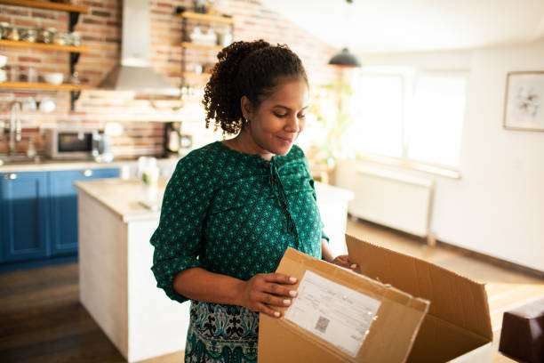 istock Young woman opening up a box she received in the mail 1490413574