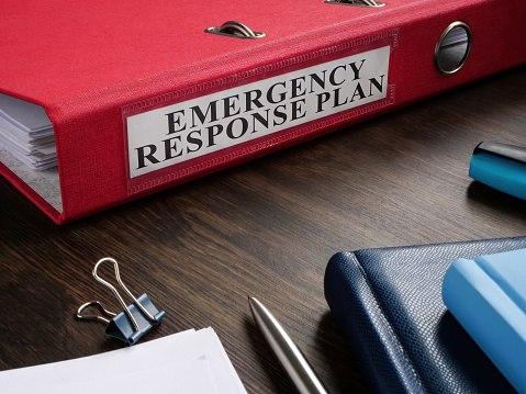 Carpeta roja con el plan de respuesta de emergencia en el escritorio. photo