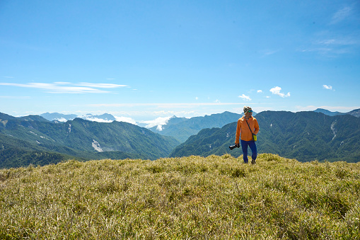 Hikers stand on top of a mountain looking at view.