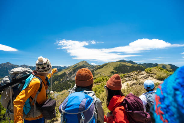istock Hikers stand on top of a mountain looking at view. 1490414761