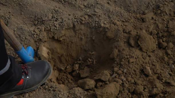 istock Shovel digging hole in the ground. Close up 1490415418