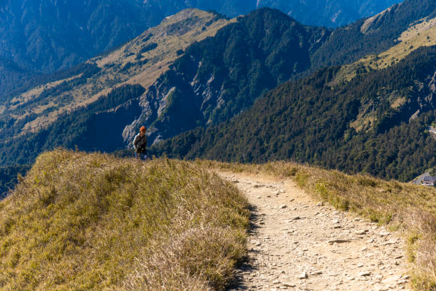 Hikers walking alone on top of a mountain.
