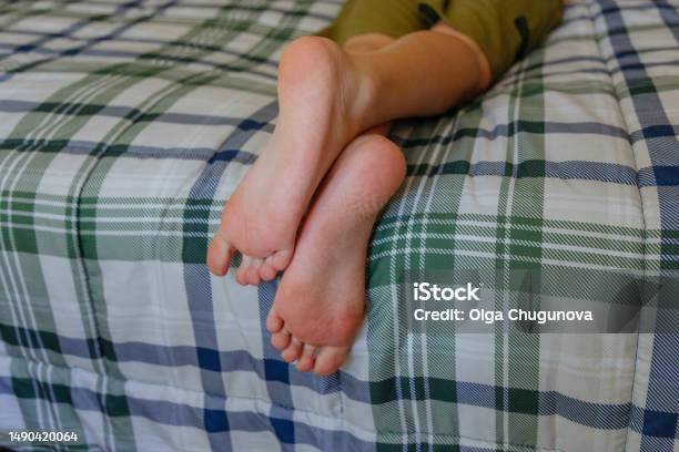 Kaki Telanjang Seorang Anak Sekolah Berbaring Di Tempat Tidur Dan