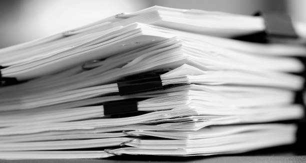 istock Pile of Papers with Binder Clips for Organizing on Desk Work to be Done 1490420405