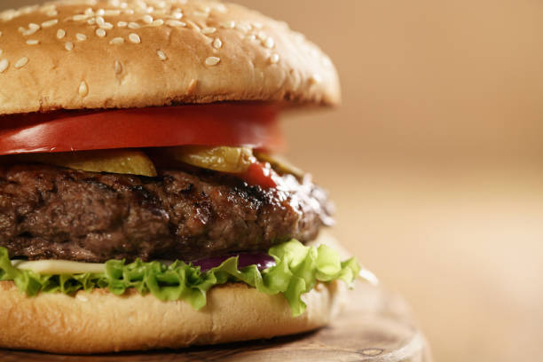 istock closeup fresh homemade burger with marble beef, cheese and vegetables on olive board 1490421179