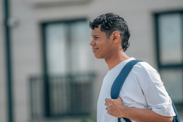 istock young latino man with backpack in the street 1490422418