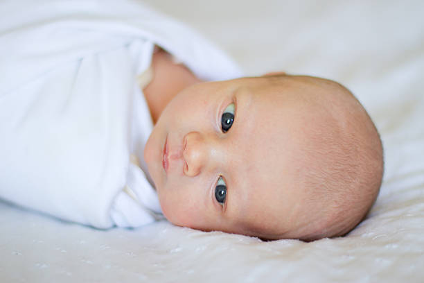 Relaxed newborn baby on bed stock photo