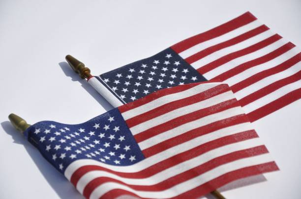istock Flagpoles with a small US flag attached, on a white background 1490424299