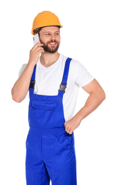 istock Professional repairman in uniform talking on smartphone against white background 1490425353