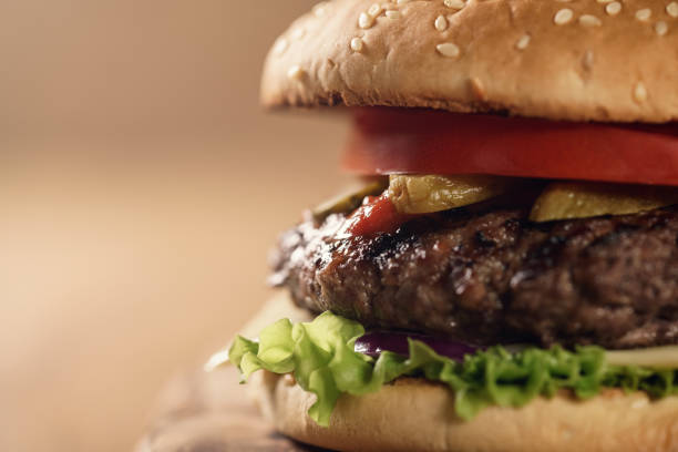 istock closeup fresh homemade burger with marble beef, cheese and vegetables on olive board 1490425692
