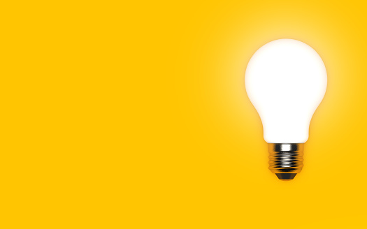 Glowing light bulb isolated on a bright yellow background