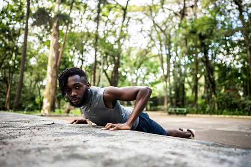 Portrait of a young man doing push ups in the park