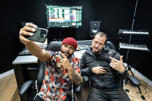 Producer men taking a selfie or filming in the recording studio