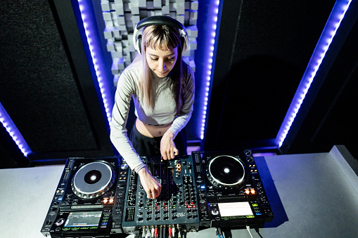 Dj young woman playing musics in a nightclub