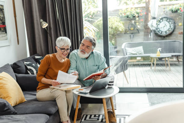 istock Senior couple discussing home finances and using laptop 1490441007