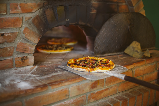 Baked pizza on a shovel , just baked from the wood oven