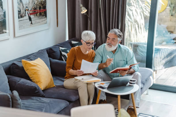 istock Senior couple discussing home finances and using laptop 1490441509