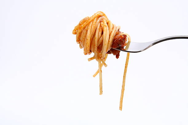 A bite of spaghetti Bolognese isolated on a fork stock photo
