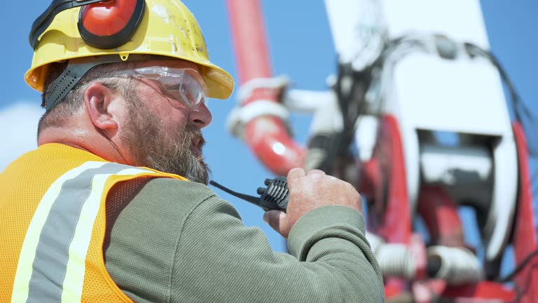 Construction worker directing concrete pump truck