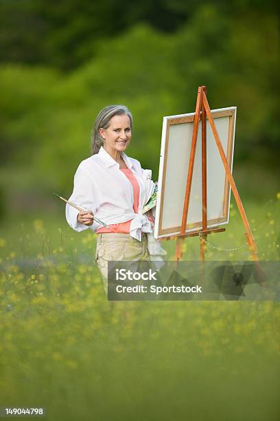 Mujer Con Caballete En El Campo De Flores Silvestres Foto de stock y más banco de imágenes de Pintar