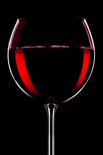 istock Red wine in a glass, on a black background. 1490448004