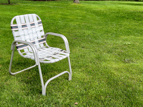 Retro folding lawn chair on green grass